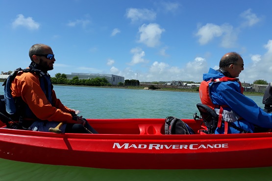 Guided kayak tour with two men sitting in red kayak